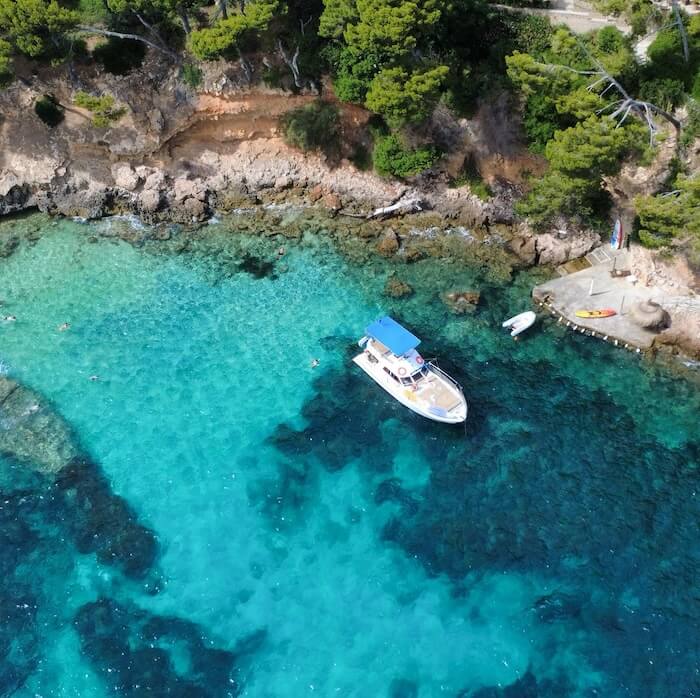Diving into clear water from the back platform of the boat.
